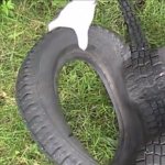 Выворачивание старой покрышки для изготовления лебедя